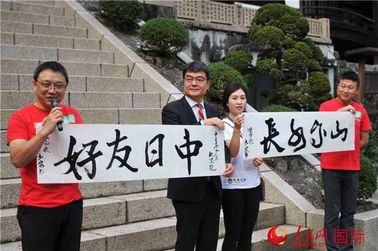 東京中國(guó)文化中心主任羅玉泉展示其為本次活動(dòng)書(shū)寫(xiě)的題詞“中日友好，山高水長(zhǎng)”。人民網(wǎng) 蔣曉辰攝