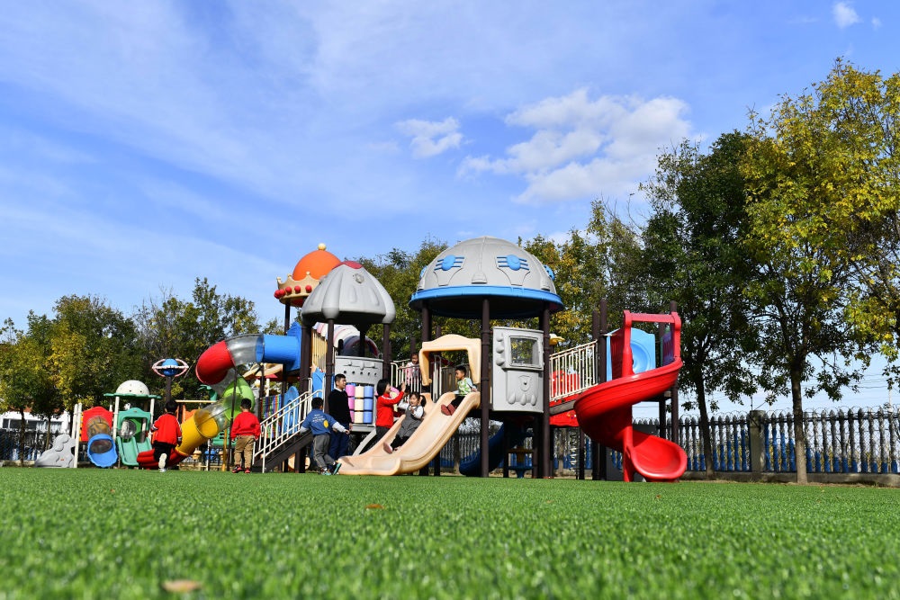 在山東省東營市墾利區(qū)楊廟社區(qū)幼兒園，孩子們在老師的帶領(lǐng)下進行戶外活動（2021年10月19日攝）。新華社記者 郭緒雷 攝