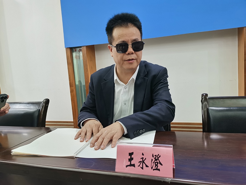 全國人大代表王永澄正在閱讀盲文版代表建議答復。本報記者 張 璁攝