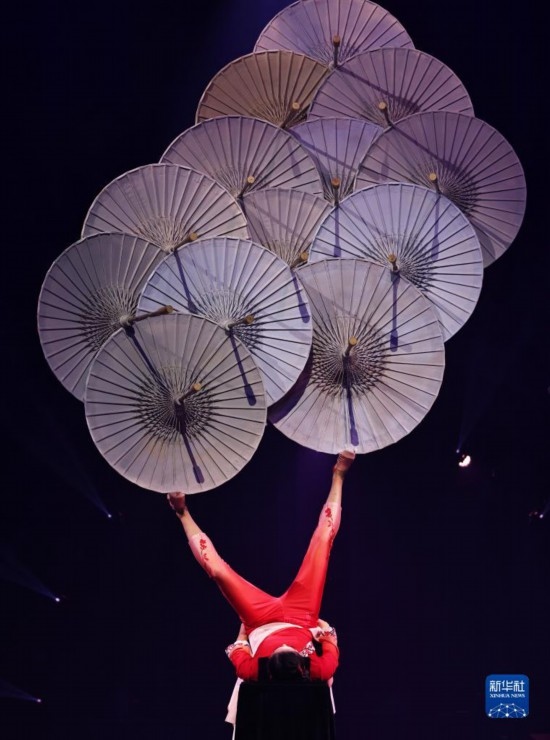 12月8日，演員在法國(guó)巴黎舉行的中國(guó)雜技“奇妙之夜”演出上表演《蹬傘》。新華社記者 高靜 攝