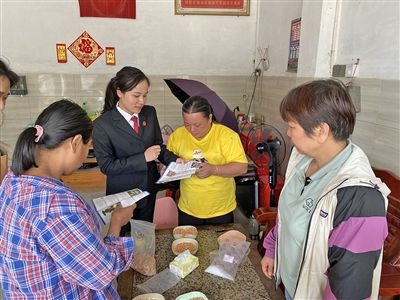  圖⑤：龍圩區(qū)法院法官到群眾家中開展法治宣傳。資料圖片