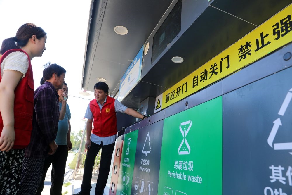 在安徽省合肥市長(zhǎng)豐縣莊墓鎮(zhèn)棗林社區(qū)，志愿者指導(dǎo)居民使用智能垃圾分類回收設(shè)備（2023年9月1日攝）。新華社記者 曹力 攝
