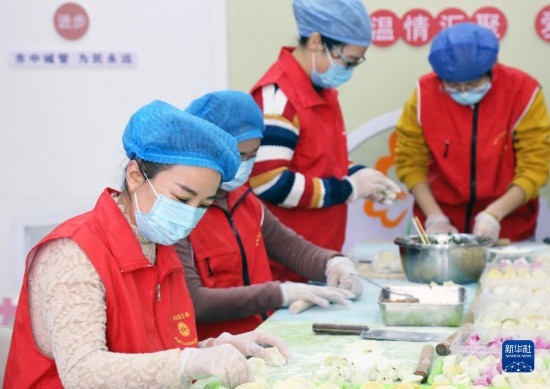 12月16日，在山東省棗莊市市中區(qū)城管藍(lán)職工志愿服務(wù)驛站，愛心志愿者為戶外勞動(dòng)者包水餃。