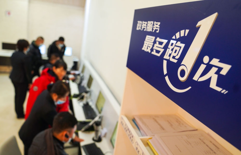 在吉林省長(zhǎng)春市二道區(qū)政務(wù)服務(wù)中心輔助填報(bào)區(qū)，市民在工作人員的輔助下進(jìn)行事項(xiàng)填報(bào)（2020年11月23日攝）。新華社記者 許暢 攝