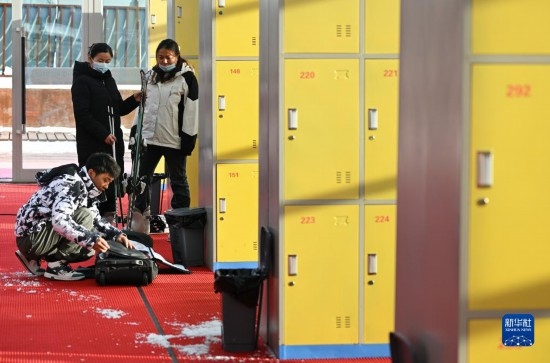 12月21日，游客在滑雪服務(wù)大廳整理滑雪裝備。