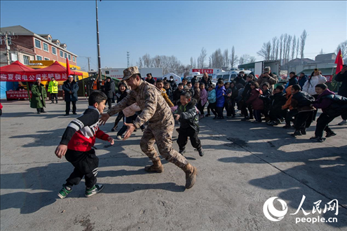 12月22日，在積石山縣大河家鎮(zhèn)大河村安置點，陸軍76集團(tuán)軍某旅官兵通過游戲方式，對小朋友進(jìn)行災(zāi)后心理疏導(dǎo)。人民網(wǎng)記者 翁奇羽攝