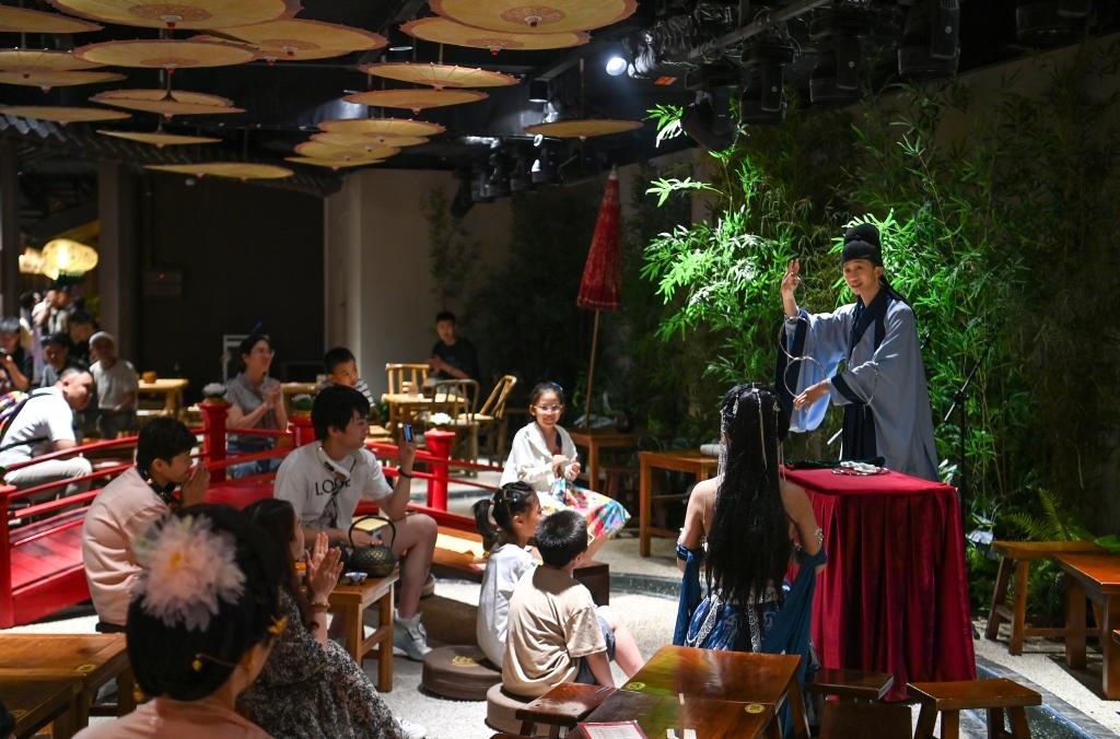 游客在長安十二時(shí)辰主題街區(qū)觀看唐風(fēng)演藝《大唐曲藝》。新華社記者鄒競一 攝