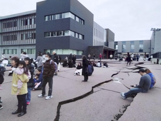  1月1日，在日本石川縣輪島市，人們站在被地震破壞的地面上。新華社/共同社
