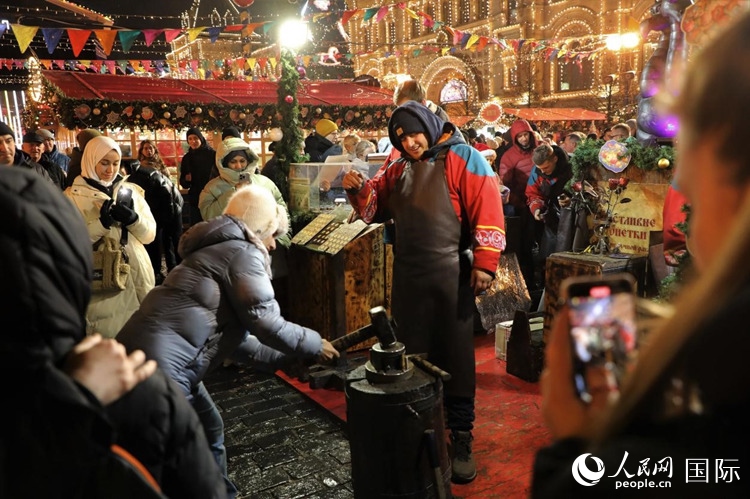 游客在新年集市上體驗制作紀念幣。人民網(wǎng)記者 隋鑫攝