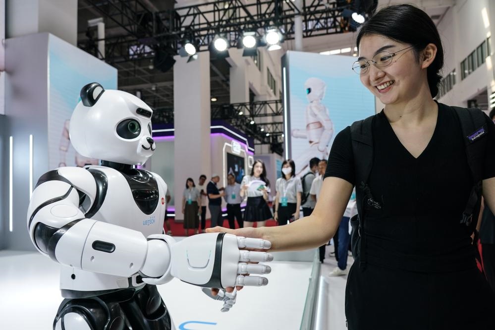 2023年8月16日，一名女士在北京舉辦的2023世界機器人大會現場與智能機器人握手。新華社記者彭子洋攝