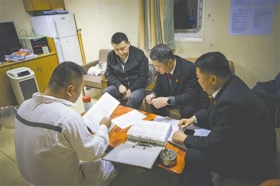 圖②：法官向船長(zhǎng)講解相關(guān)法律規(guī)定，查看船舶資料，并與船方辦理扣押船舶的手續(xù)。