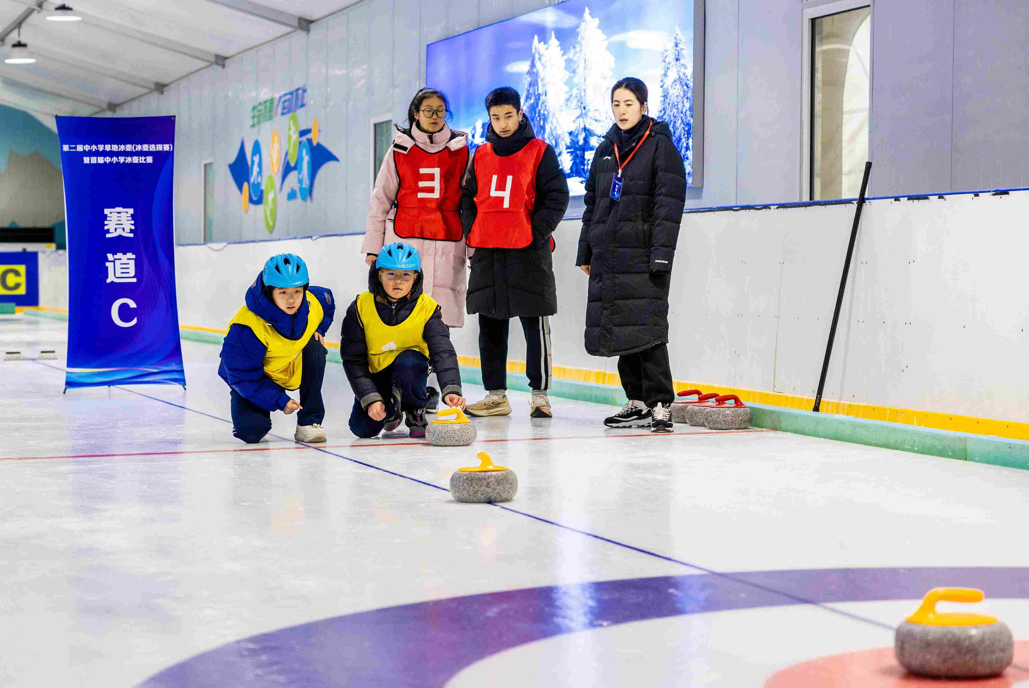 2023年12月10日，參賽選手在呼和浩特首屆中小學(xué)冰壺比賽中投擲冰壺。