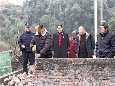  圖③：庭審結(jié)束后，在法官的見證下，陳某在院壩邊重新開鑿一條通道。