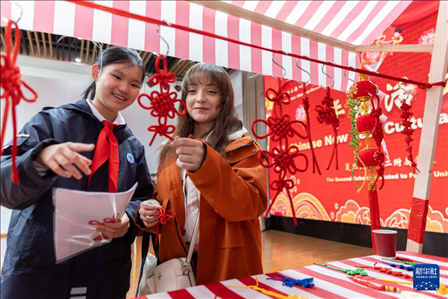 1月28日，復(fù)旦大學(xué)第二附屬學(xué)校學(xué)生（左）為美國(guó)馬斯卡廷中學(xué)學(xué)生（右）介紹中國(guó)結(jié)。 新華社記者 王翔 攝