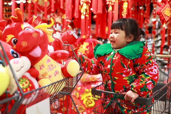 1月23日，在貴州省黔東南苗族侗族自治州岑鞏縣一家超市，小朋友在家人的帶領(lǐng)下選購(gòu)龍年毛絨玩具。新華社發(fā)（唐鵬攝）