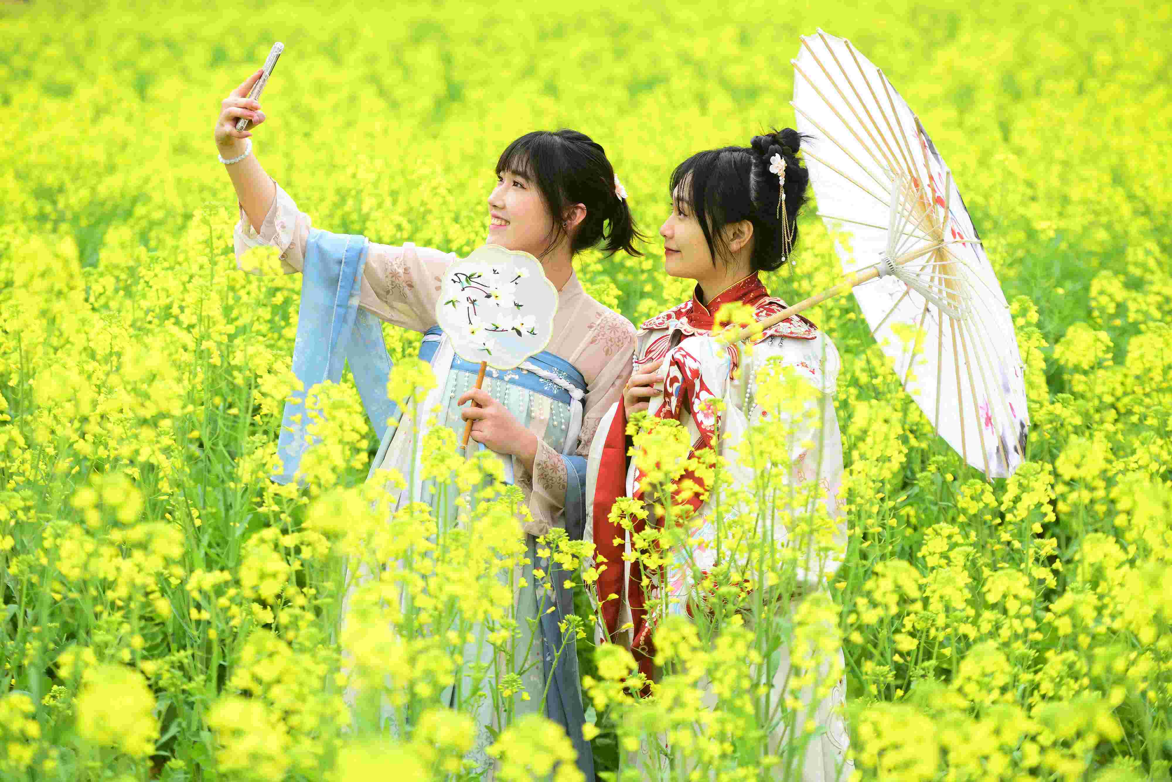 △ 2024年2月16日，廣西賀州，在富川瑤族自治縣麥嶺鎮(zhèn)三民村，游客在油菜花田間賞花拍照。