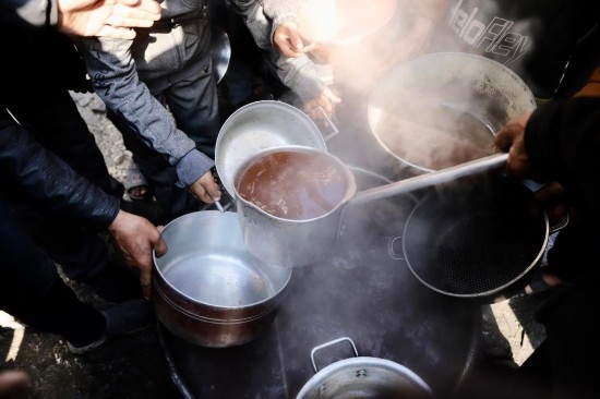  2月27日，在加沙地帶北部的杰巴利耶難民營(yíng)，人們領(lǐng)取食物。新華社發(fā)（穆罕默德·阿里攝）