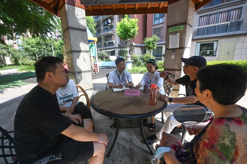 △2023年7月21日，在位于浙江杭州臨安區(qū)錦南街道水岸陽光小區(qū)的陽光議事廳，街道干部在聽取居民們反映的問題及意見。