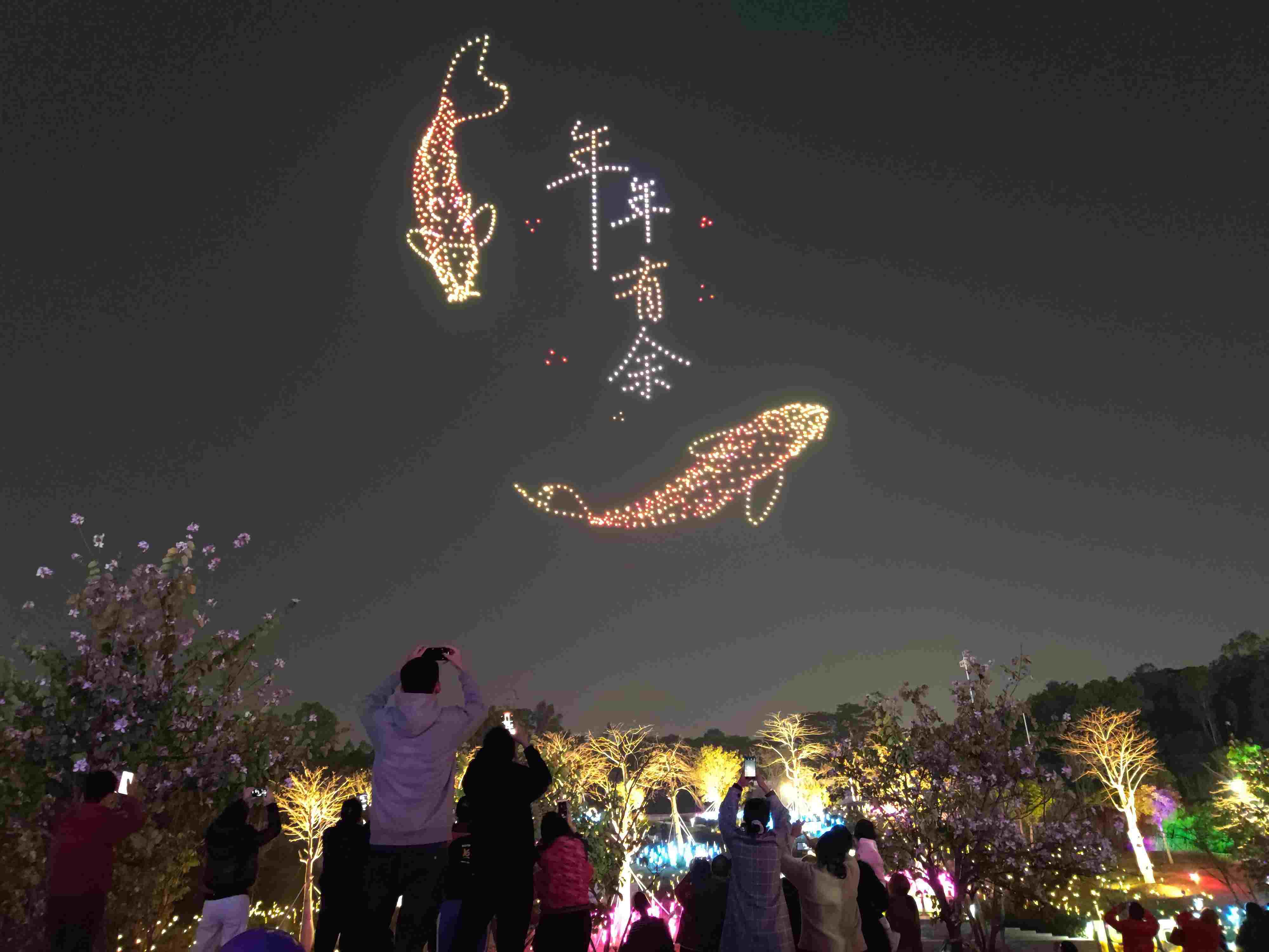 △ 2024年2月10日，深圳北站中心公園，春節(jié)主題無人機(jī)燈光秀引來眾多游客駐足觀看。