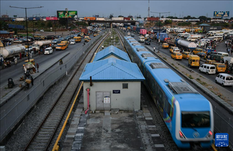 3月4日，在尼日利亞拉各斯，一列輕軌藍(lán)線列車行駛至公路交通擁堵路段附近。新華社記者 韓旭 攝