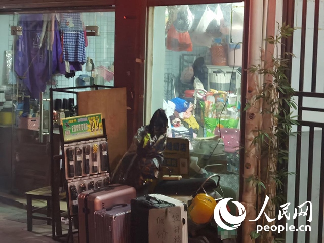 南寧“城中村”一裁縫鋪老板將電線從店內(nèi)拉出為電動自行車充電。人民網(wǎng) 覃心攝