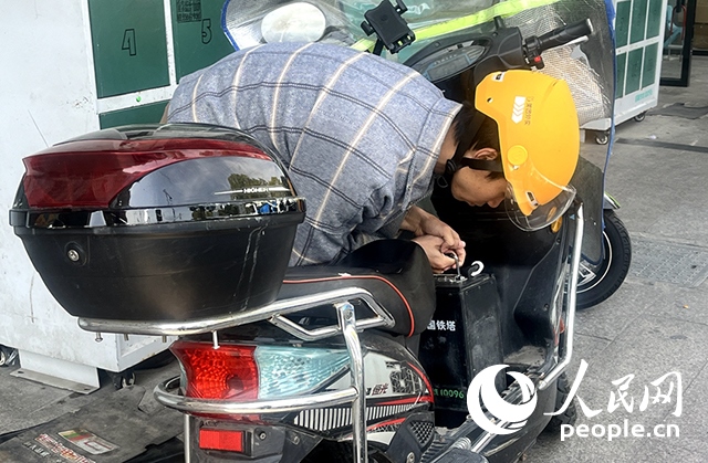 杭州一名外賣騎手正在更換共享電池。人民網(wǎng)記者 張麗瑋攝