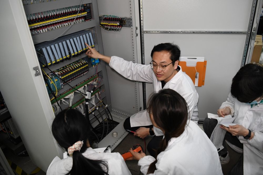 2024年4月6日，在位于安徽合肥的中國科學(xué)技術(shù)大學(xué)，安徽省先進功能高分子薄膜工程實驗室團隊成員在檢修自主研制的高分子薄膜原位雙向拉伸實驗設(shè)備的電氣控制系統(tǒng)。