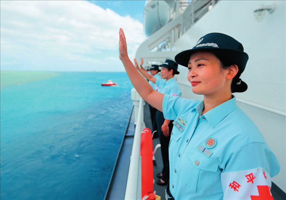 中國海軍“和平方舟”號(hào)醫(yī)院船結(jié)束訪問湯加時(shí)，任務(wù)官兵中的文職人員向歡送人群揮手告別（2023年8月4日攝）。徐巍攝/本刊