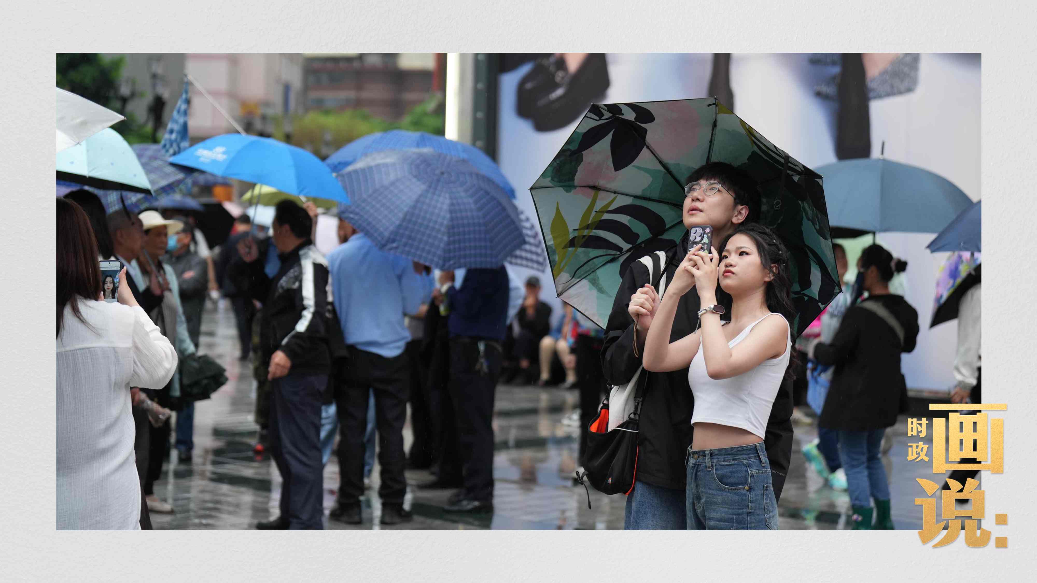△細雨中的解放碑步行街，騎在父親肩膀的小女孩好奇張望。