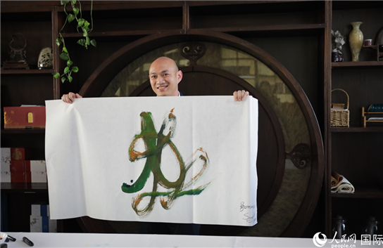 老撾駐華大使館三秘明君參加《五百筆·瀾湄合作》集體藝術(shù)創(chuàng)作。人民網(wǎng)王婧攝。