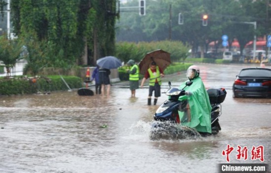 5月10日，廣西沿海遭遇強(qiáng)降雨。圖為欽州市民眾在積澇中出行。陸敏 攝