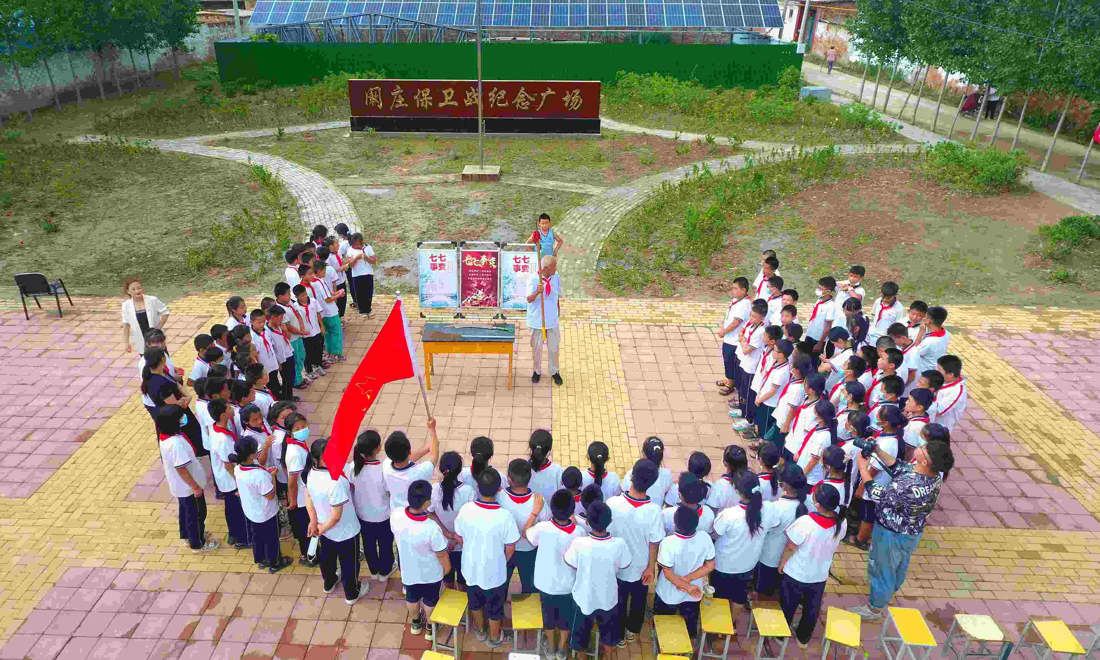 2022年7月6日，山東省聊城市，在茌平區(qū)菜屯鎮(zhèn)闞莊村的闞莊保衛(wèi)戰(zhàn)紀(jì)念廣場，闞莊保衛(wèi)戰(zhàn)親歷者王光木老人為小學(xué)生們講述抗戰(zhàn)故事，展示大刀、長矛。