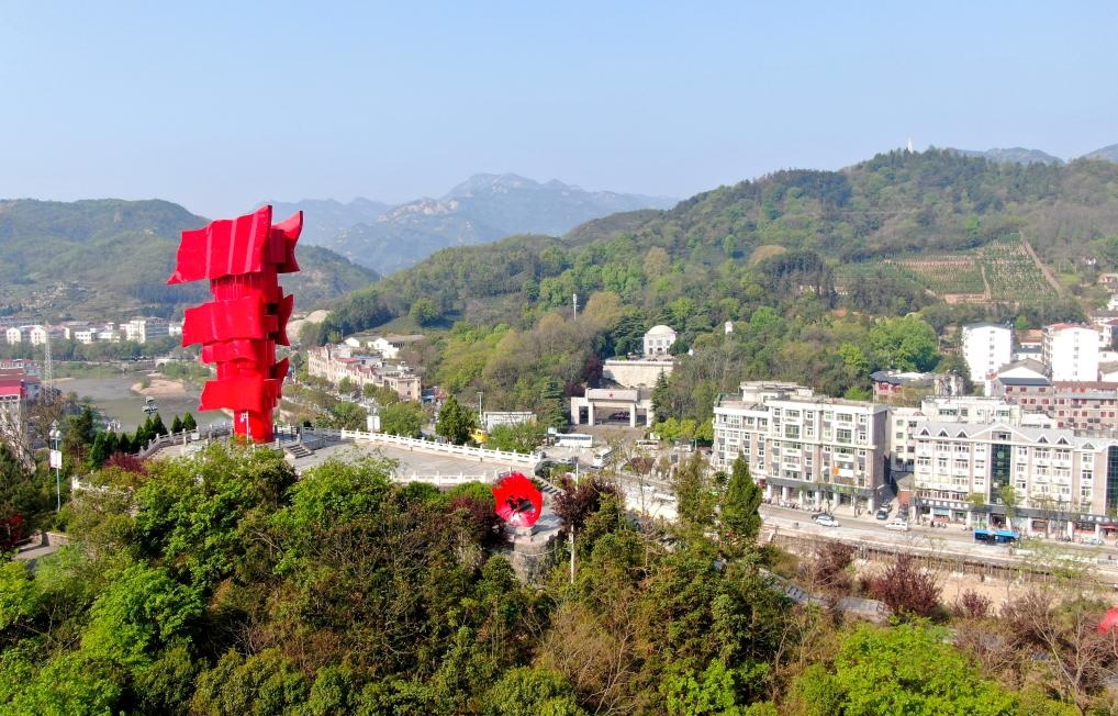 這是2021年4月9日拍攝的鄂豫皖蘇區(qū)首府革命博物館附近的英雄山上的“紅旗飄飄”主題雕塑（無(wú)人機(jī)照片）。新華社發(fā)