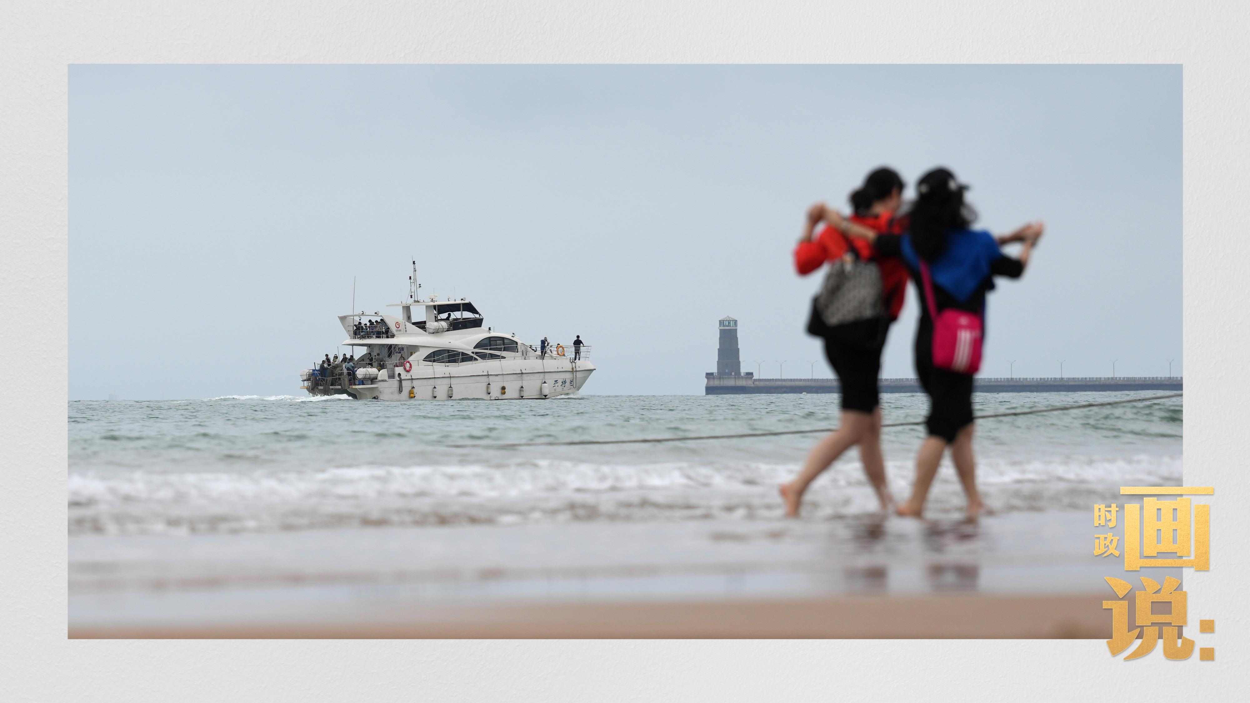 △日照陽光海岸綠道上的萬平口景區(qū)，一對游客在海浪中翩然起舞。