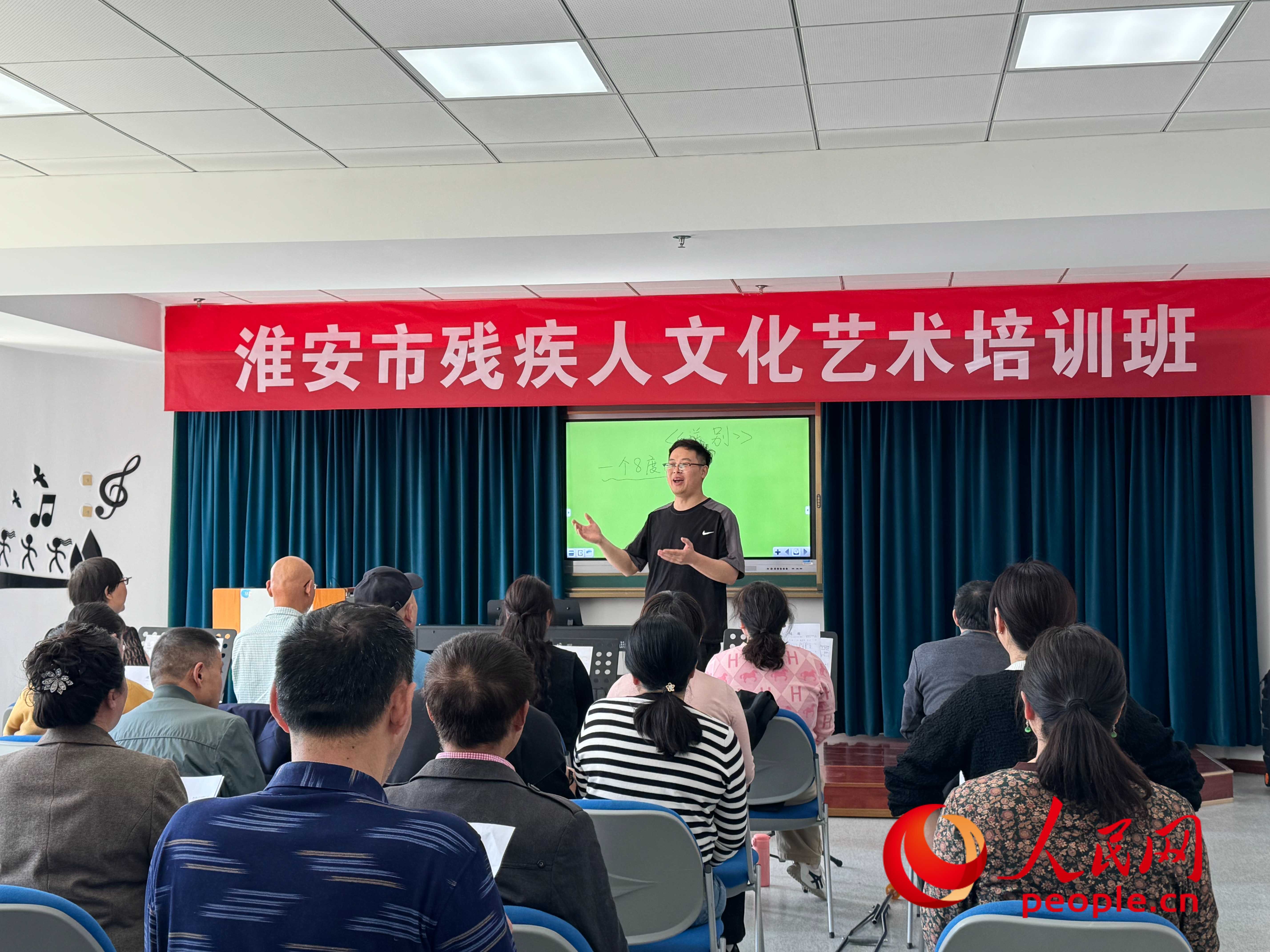 在淮安市殘疾人文化藝術(shù)培訓(xùn)班上，聲樂老師在教殘疾人唱《送別》這首歌曲。人民網(wǎng) 周靜圓攝