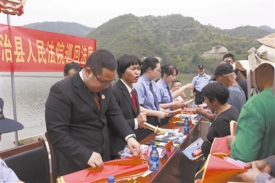 法院干警及相關(guān)部門工作人員對群眾進(jìn)行生態(tài)環(huán)境保護(hù)普法教育。