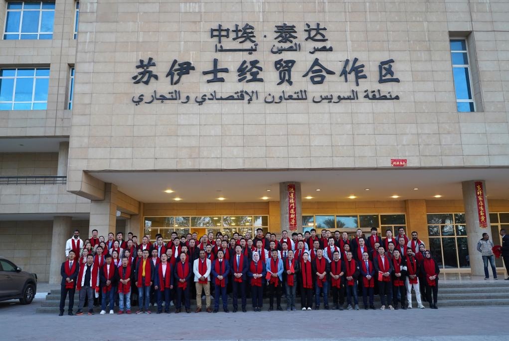 2024年2月11日，在位于埃及蘇伊士省的中?！ぬ┻_(dá)蘇伊士經(jīng)貿(mào)合作區(qū)，中埃員工在合作區(qū)辦公大樓前合影拜年。新華社發(fā)（泰達(dá)合作區(qū)供圖）