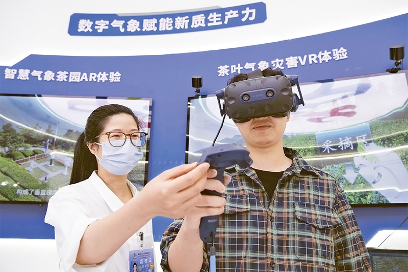 2024年5月23日，第七屆數(shù)字中國建設(shè)峰會現(xiàn)場體驗區(qū)在福州海峽國際會展中心向?qū)I(yè)觀眾開放。本次現(xiàn)場體驗區(qū)圍繞本屆峰會主題“釋放數(shù)據(jù)要素價值，發(fā)展新質(zhì)生產(chǎn)力”，設(shè)置“數(shù)字惠民”、“數(shù)字能力”、“數(shù)字基礎(chǔ)”、“數(shù)字生態(tài)”、“數(shù)字賦能”五大板塊。圖為一名觀眾（右）在數(shù)字氣象賦能新質(zhì)生產(chǎn)力展臺上進行體驗。 新華社記者 魏培全/攝