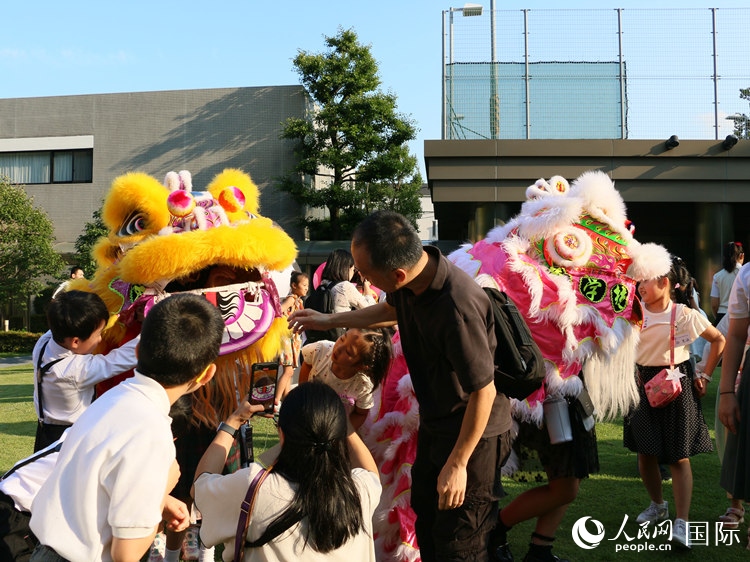 孩子們好奇地圍觀舞獅。人民網(wǎng) 許可攝