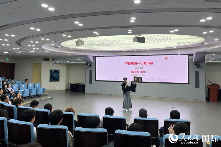 日本大學(xué)生介紹能樂知識。人民網(wǎng)記者 陳思攝