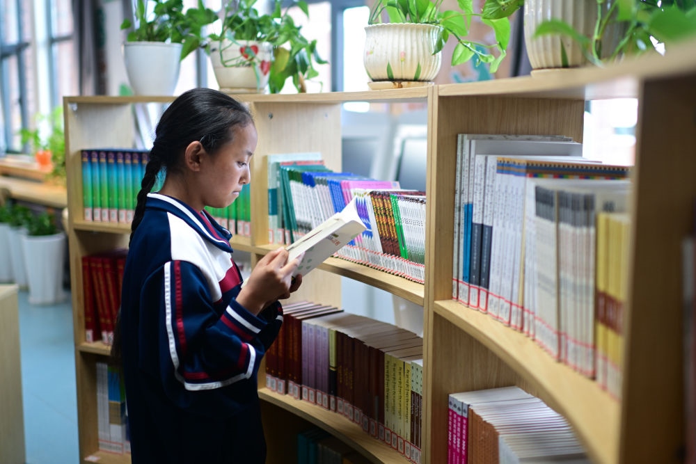 6月18日，果洛西寧民族中學(xué)學(xué)生尼東拉毛在圖書室看書。