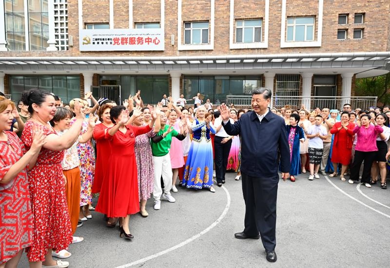 2022年7月13日，習(xí)近平總書記在新疆烏魯木齊市天山區(qū)固原巷社區(qū)考察時(shí)，向各族群眾揮手致意。