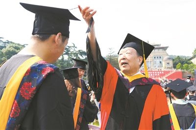 2017年6月22日，李德仁（右一）參加武漢大學(xué)畢業(yè)典禮并為畢業(yè)生撥穗。
