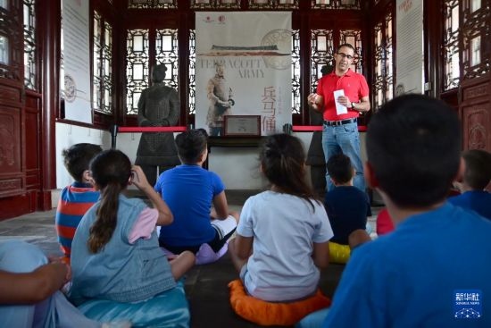 7月4日，在馬耳他桑塔露琪亞市的中國古典園林“靜園”，人們聆聽關(guān)于兵馬俑的講解。新華社發(fā)（喬納森·博格 攝）