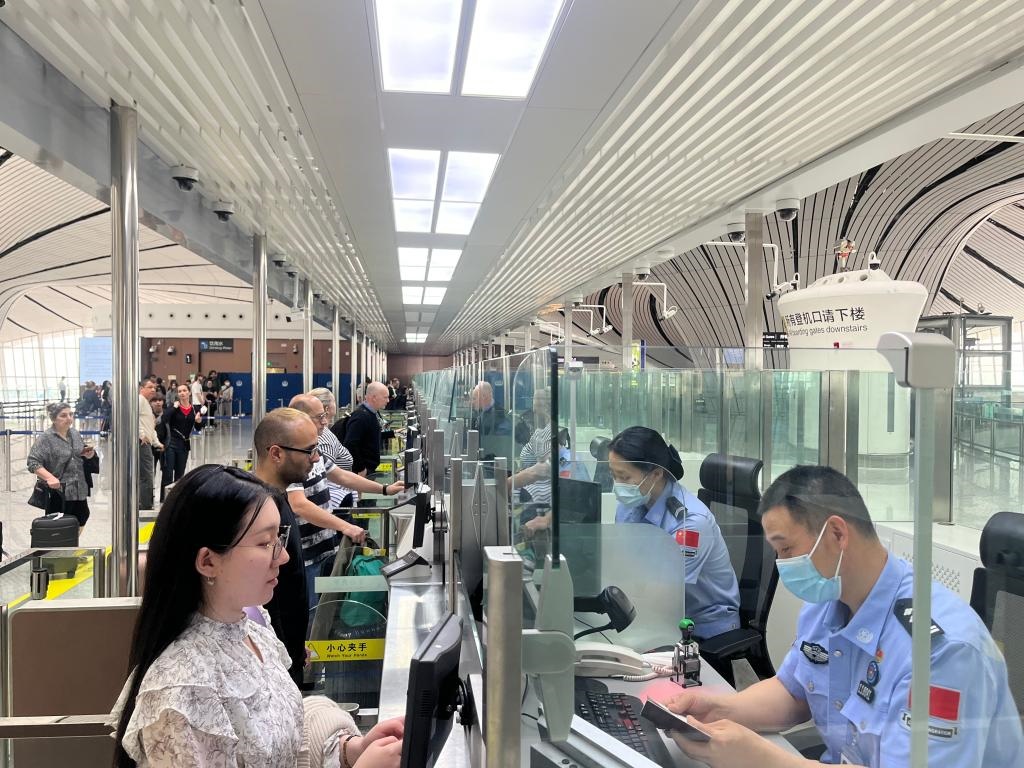 7月5日，北京大興國(guó)際機(jī)場(chǎng)邊檢站民警正在辦理邊檢查驗(yàn)手續(xù)。（北京大興國(guó)際機(jī)場(chǎng)邊檢站供圖）