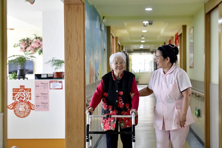 2024年5月25日，在山東省日照市東港區(qū)石臼街道日照幸福護(hù)理院，工作人員在陪護(hù)老人。新華社記者 郭緒雷 攝