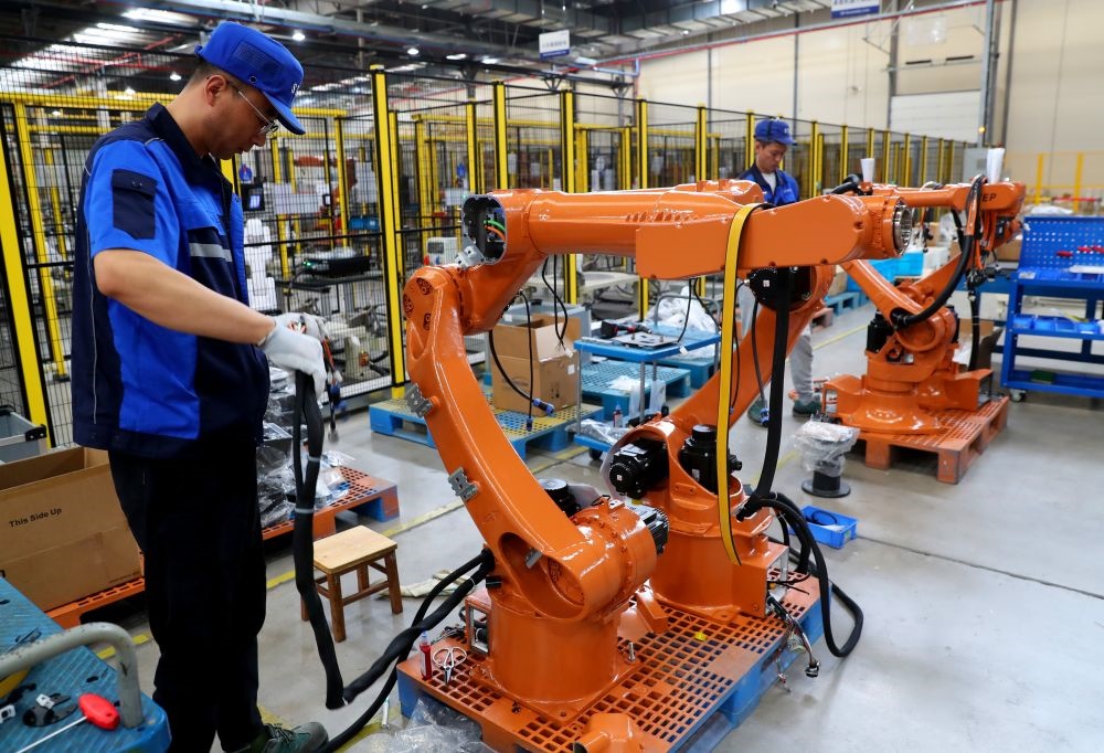 工作人員在上海新時(shí)達(dá)機(jī)器人有限公司位于嘉定的智能工廠內(nèi)忙碌（2024年5月23日攝）。新華社記者 龔兵 攝