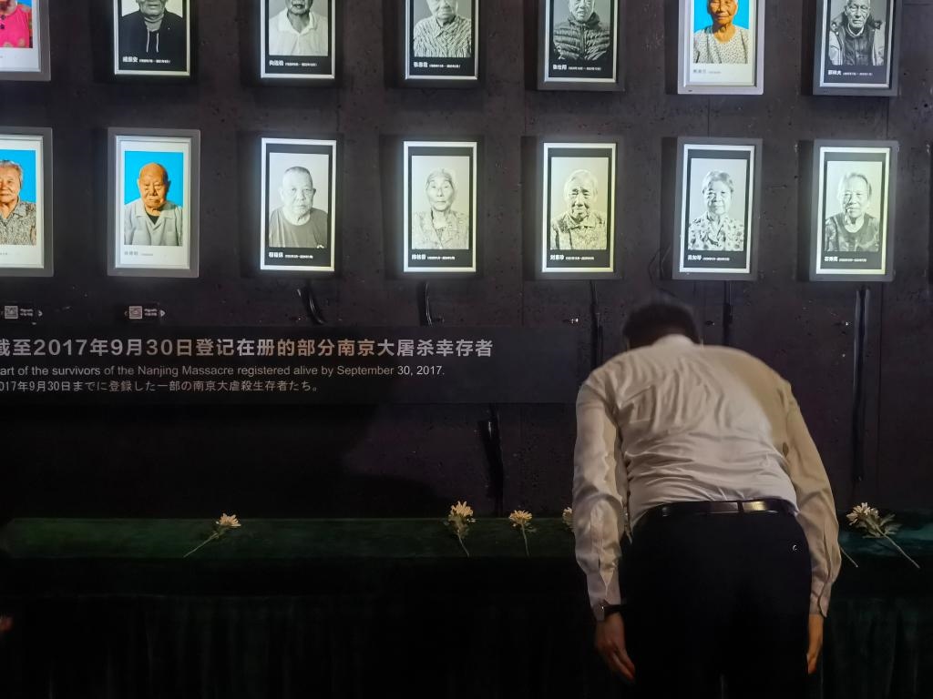 7月18日，人們向離世的南京大屠殺幸存者獻花、鞠躬。新華社記者邱冰清 攝