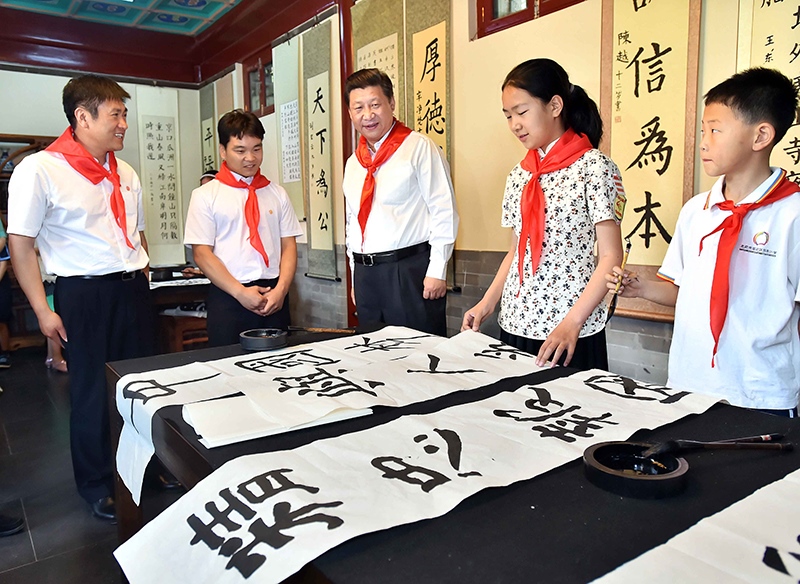 2014年5月30日，習近平總書記來到北京市海淀區(qū)民族小學，參加慶?！傲弧眹H兒童節(jié)活動。這是總書記觀看學生書寫的毛筆字。