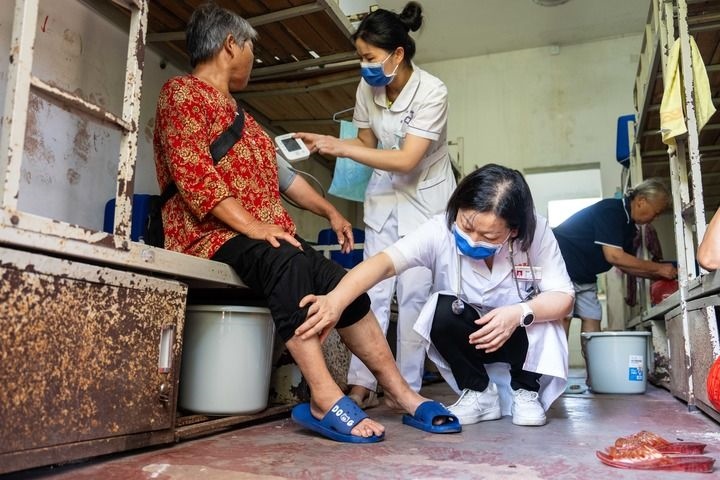 2024年7月30日，在湖南省湘潭縣河口中學(xué)安置點(diǎn)，醫(yī)務(wù)人員為受洪水影響而轉(zhuǎn)移安置的群眾檢查身體。 新華社記者 陳思汗 攝